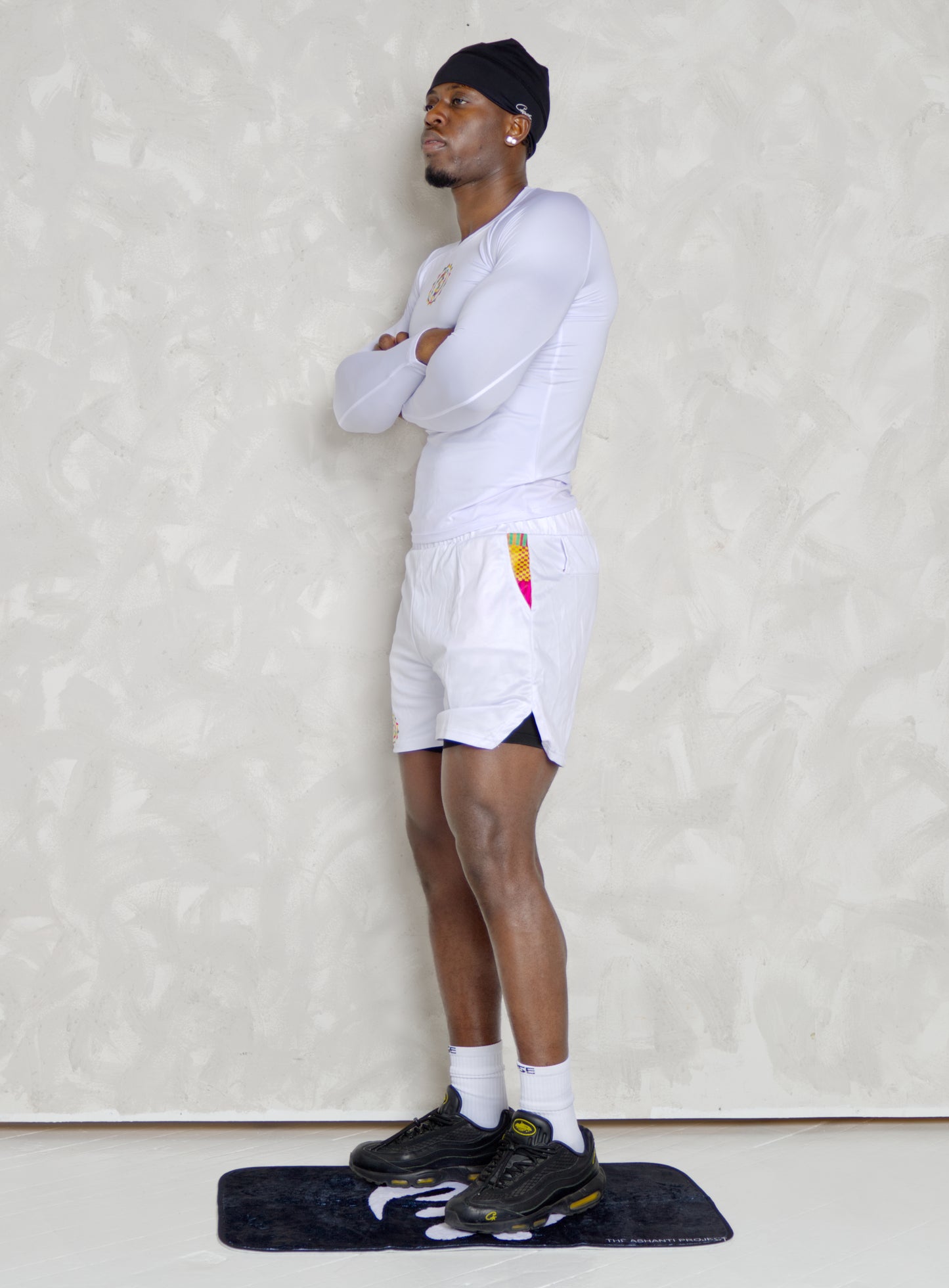 Black Man wearing active long sleeve kente shirt and white shorts with compression
