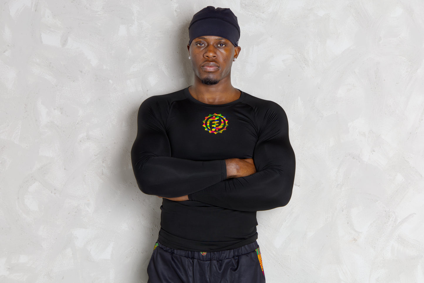 Person wearing a black athletic outfit with kente  logos on a white background. comes with a compression shorts 