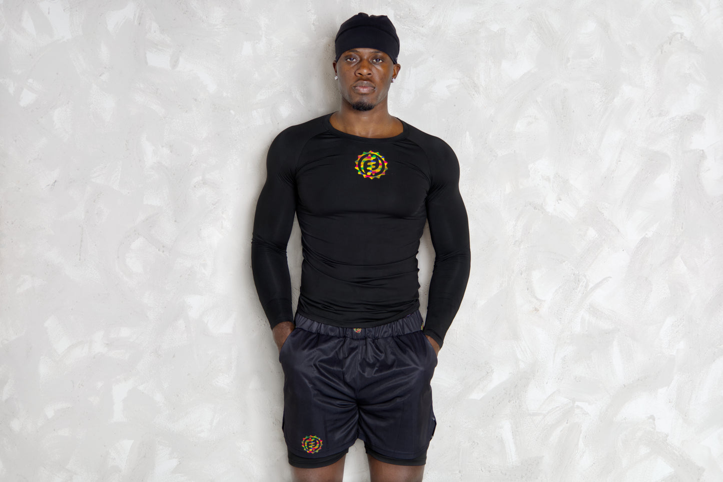 Person wearing a black athletic outfit with a logo on a textured white background