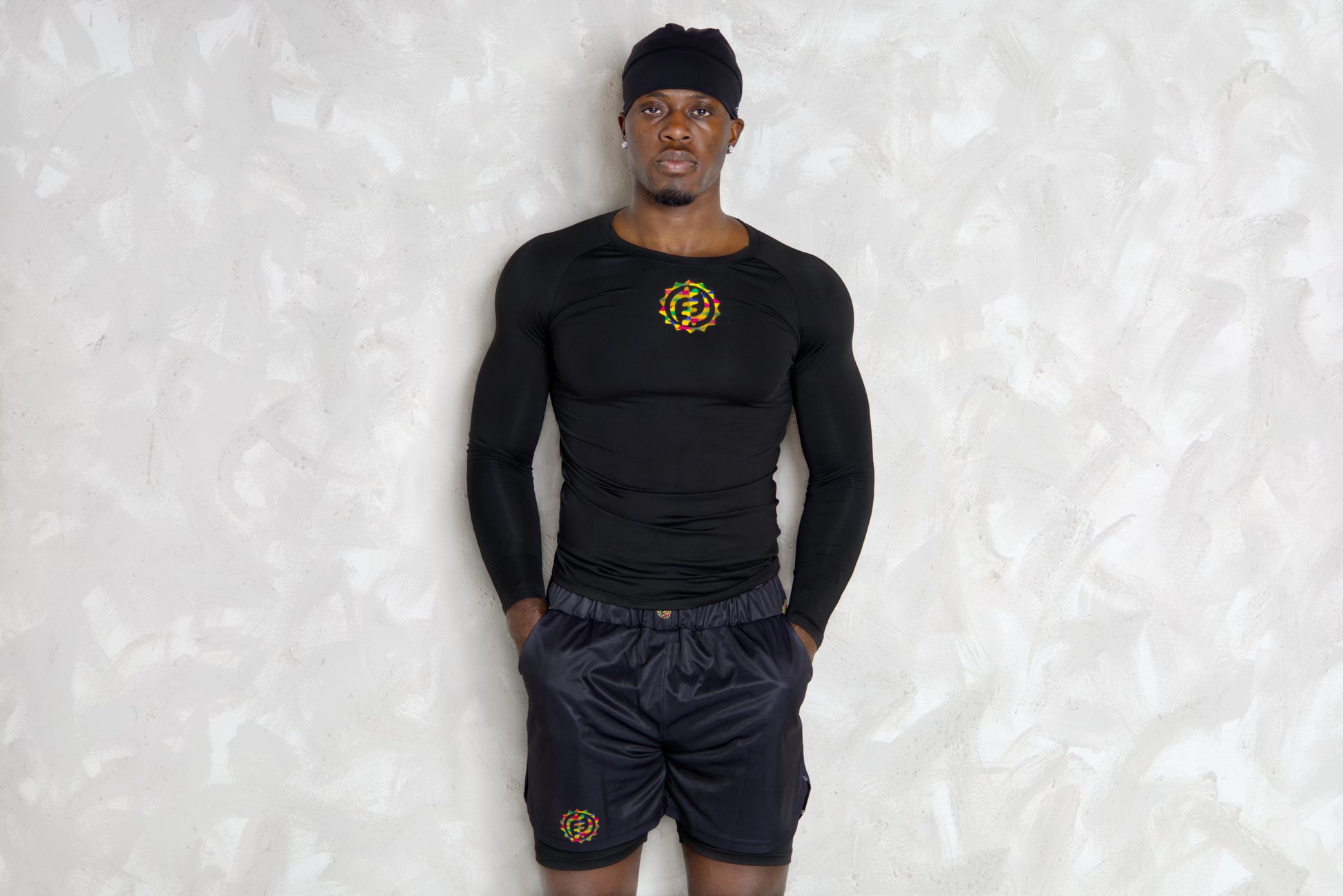 Person wearing a black athletic outfit with a logo on a textured white background