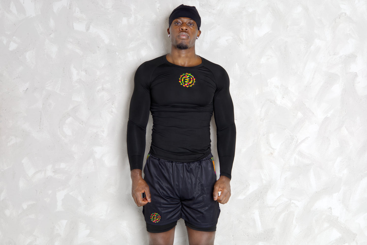 Person wearing a black athletic outfit with kente  logos on a white background. comes with a compression shorts 