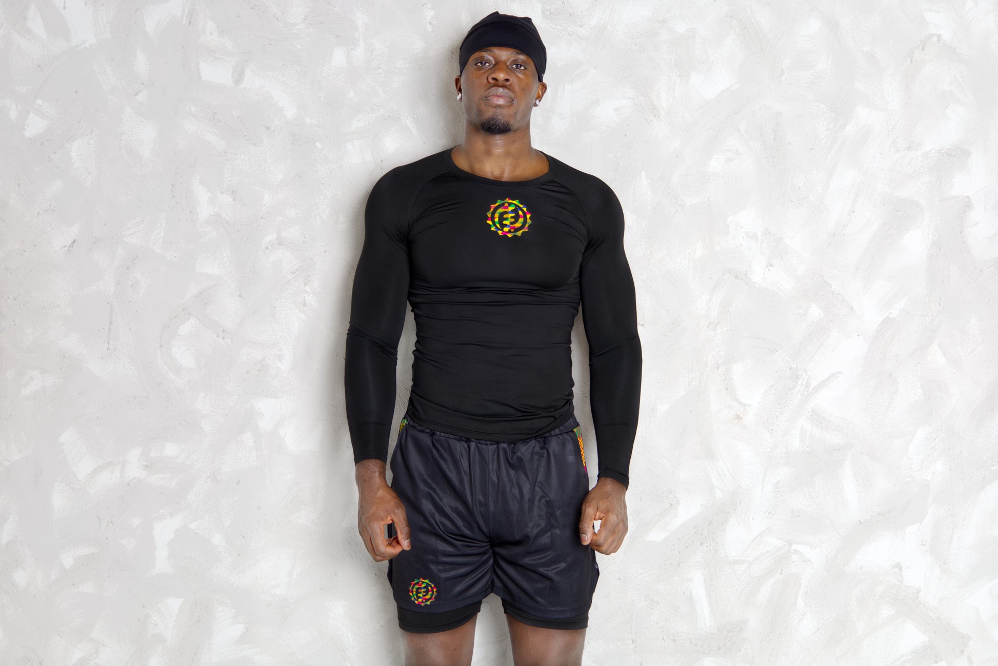 Person wearing a black athletic outfit with kente  logos on a white background. comes with a compression shorts 